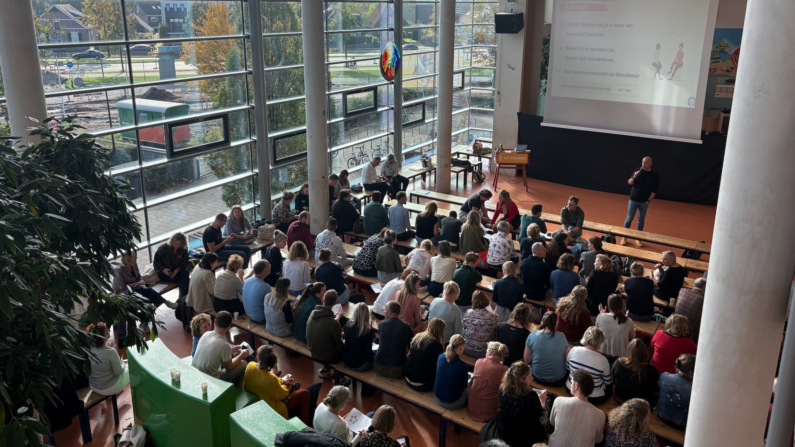 Een groep onderwijsprofessionals overlegt tijdens een gezamenlijke bijeenkomst