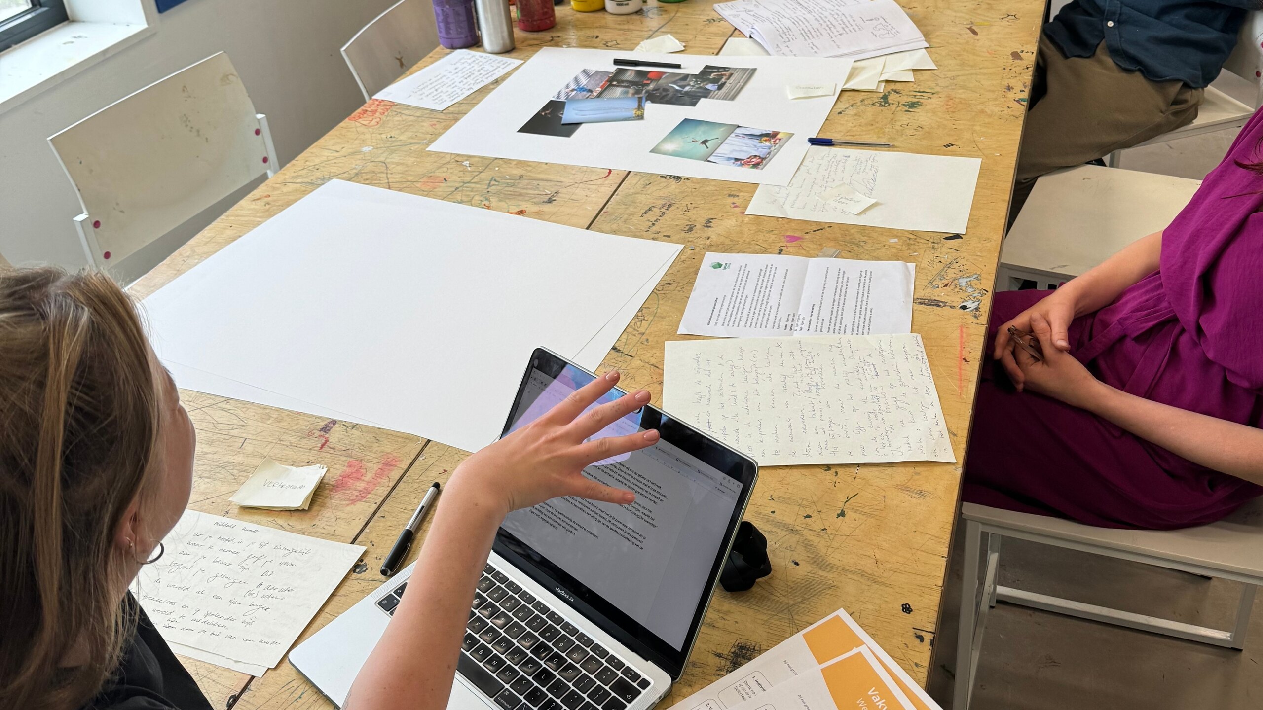 Deelnemers bespreken hun onderwijs met werkbladen en een laptop aan tafel