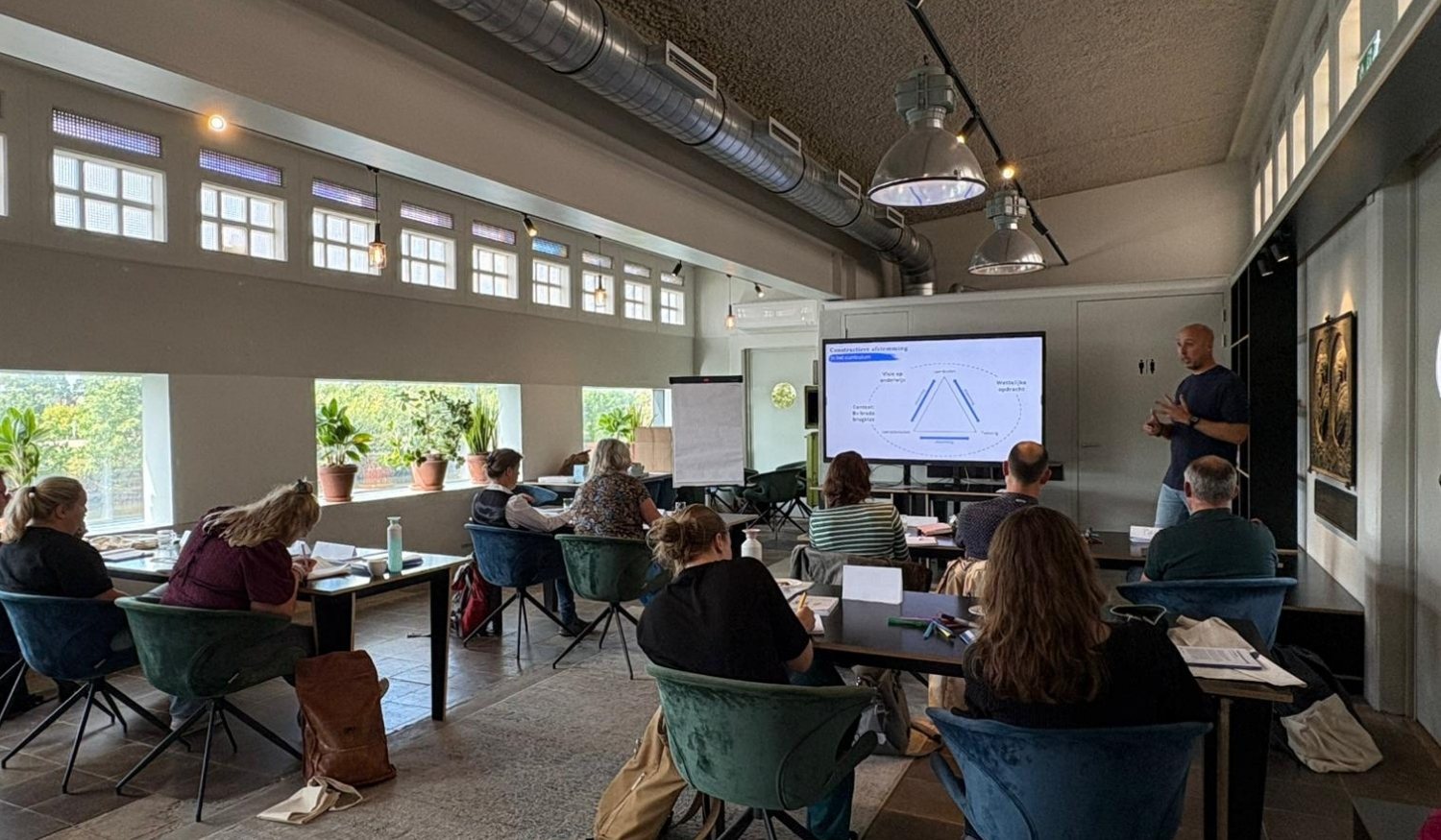 Een schoolteam volgt een bijeenkomst over curriculumontwikkeling